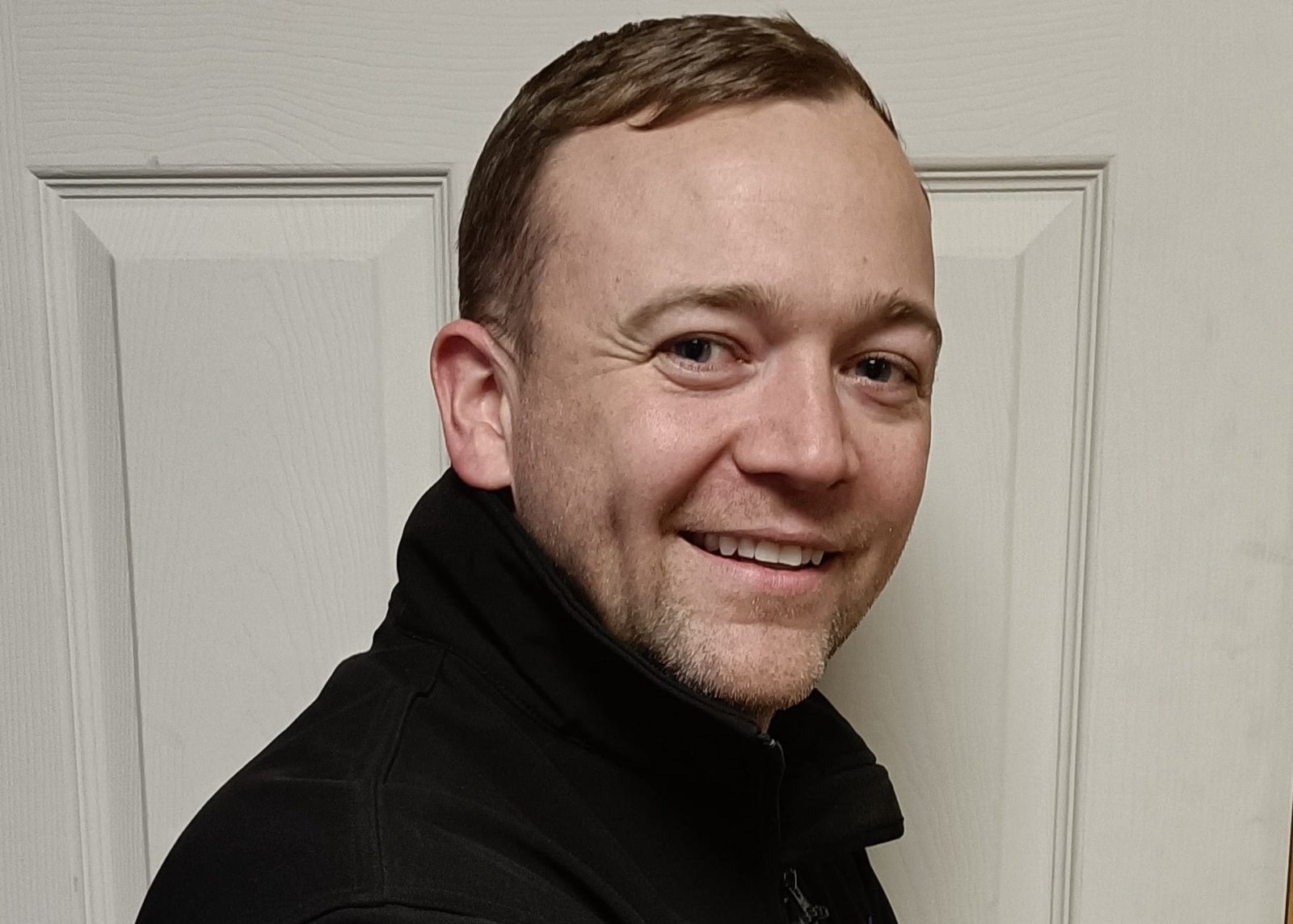 a man in a black jacket and a white shirt